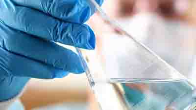 实验室里，一位男科学家手臂上拿着空试管。